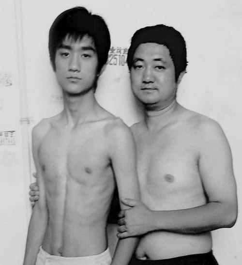 Photo en noir et blanc d'un père et de son fils torse-nu en 2002