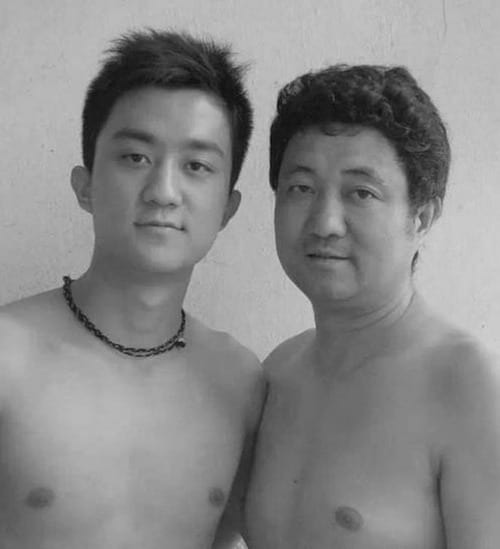 Photo en noir et blanc d'un père et de son fils torse-nu en 2004