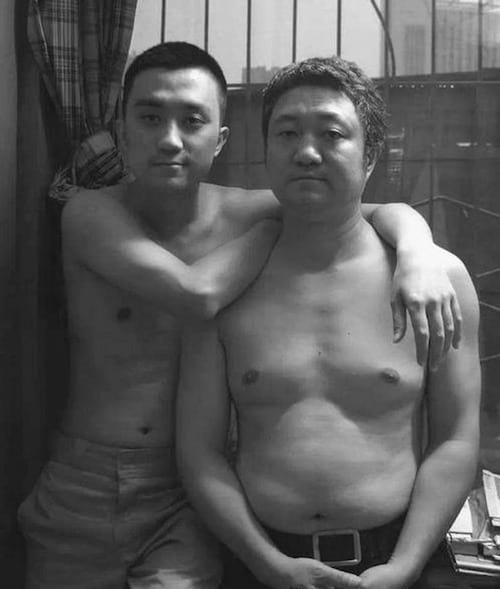 Photo en noir et blanc d'un père et de son fils torse-nu en 2009