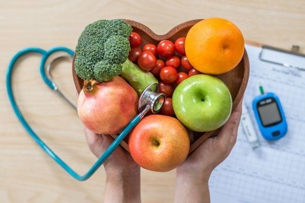 Une corbeille de fruits et de légumes en forme de coeur avec un stéthoscope