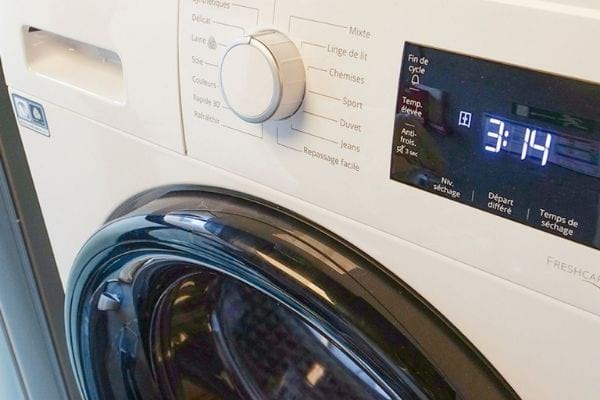 Un sèche-linge blanc qui doit être éteint pour baisser la facture