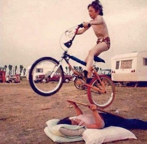 Petit garçon passant une rampe avec une Femme en dessous sur son vélo 