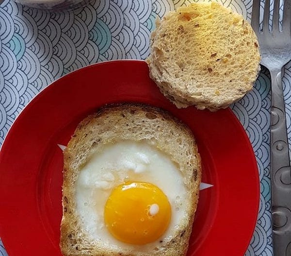 un oeuf au plat cuit sur une tranche de pain de mie pour le petit déjeuner