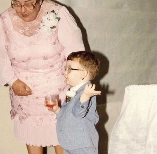 Petit garçon en costume avec un verre à la main 