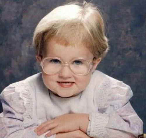 Une petite fille bébé avec des lunettes et un regard ressemblant à Mme.Doubtfire