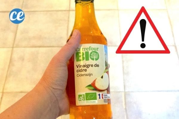 Une bouteille de vinaigre de cidre tenue dans une main