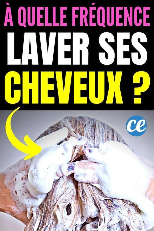 Une femme souriante se lave les cheveux avec beaucoup de shampoing