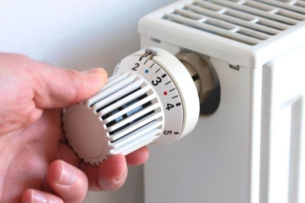 Une main qui allume le chauffage pour la journée