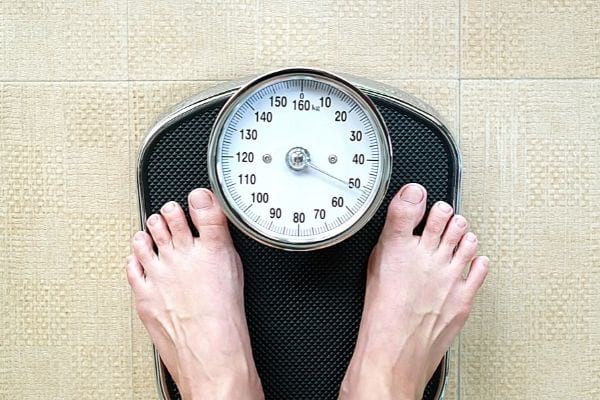 un pèse personne noir avec une personne dessus