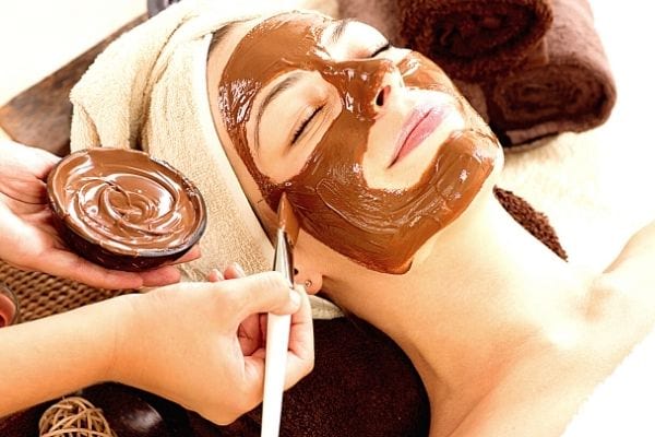 une femme se fait faire un masque au chocolat