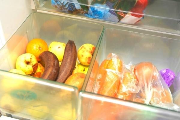 Des bananes très mures dans un bac d'un frigo
