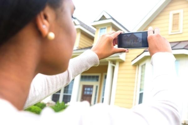 Une femme qui prend une photo avec téléphone et qui laisse des indices pour des escrocs du bon coin