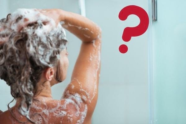 une jeune femme se laver les cheveux sous la douche