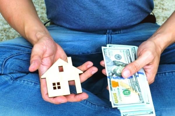 Un homme tenant des billets prêts à verser une caution suite à une annonce le bon coin