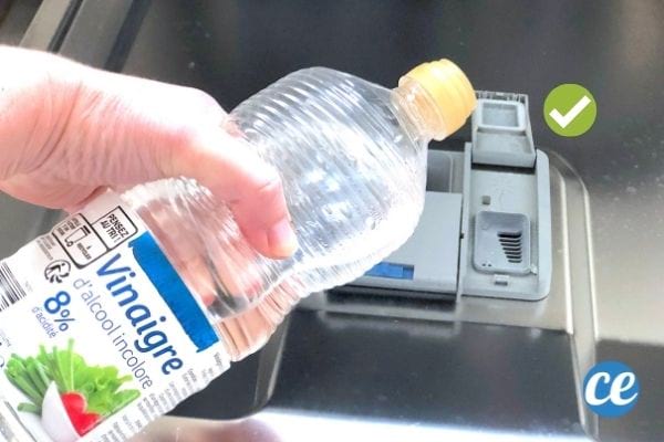 Du vinaigre blanc versé dans le bac du liquide de rinçage du lave-vaisselle