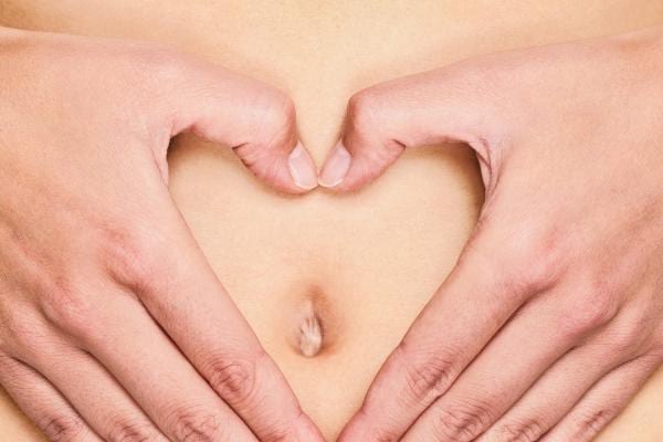 Mains devant le ventre pour une digestion facilité grâce à la banane