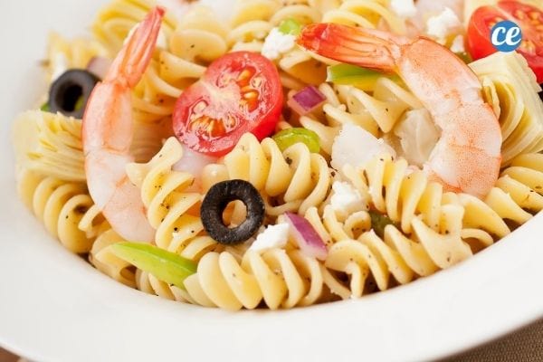 A fusilli pasta salad with tomato, shrimps, olives