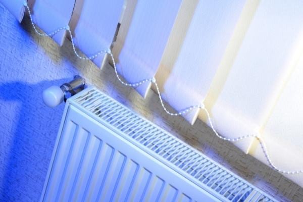 Un radiateur sous une fenêtre et rideau pour économiser de l'énergie