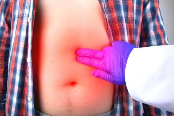 Un doigt posé sur une ulcère d'estomac qui se soigne grâce aux bienfaits de la banane