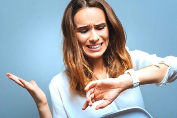 Une femme crispée qui regarde sa montre