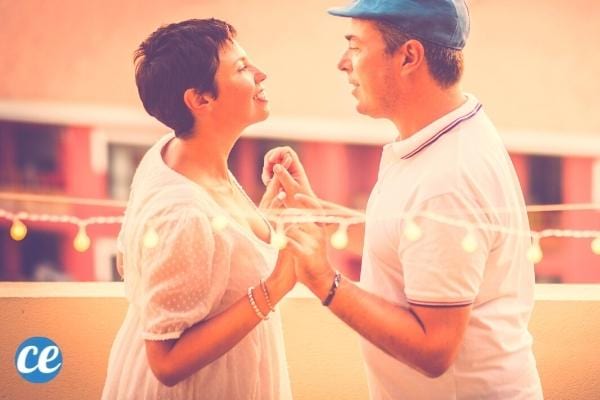 Un couple qui se tient les mains se regardant dans les yeux et qui danse ensemble 