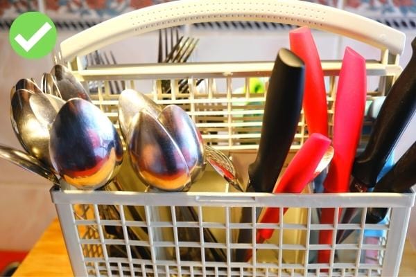 Plusieurs couverts rangés dans un panier de lave-vaisselle