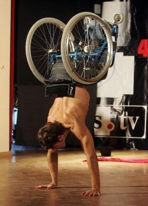 Un homme sur une chaise roulante faisant un poirier