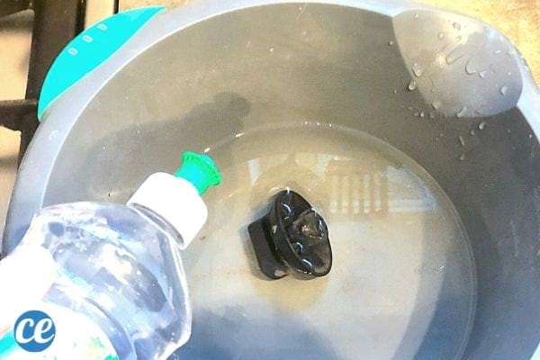 Nettoyer le bouton de la gazinière dans une bassine avec de l'eau chaude et du liquide vaisselle