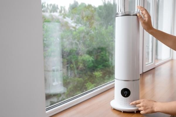 Une femme actionnant un humidificateur pouvant provoquer de la condensation