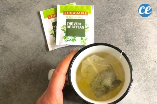 une tasse de thé vert avec deux sachets de thé