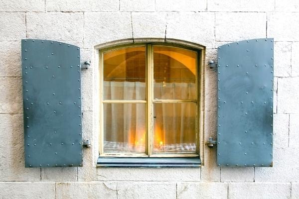 Des volets de fenêtre bleu ouverts qui font consommer plus d'énergie à la maison