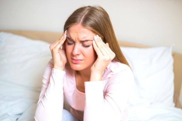 Une femme avec un mal de tête à cause d'une carence en fer