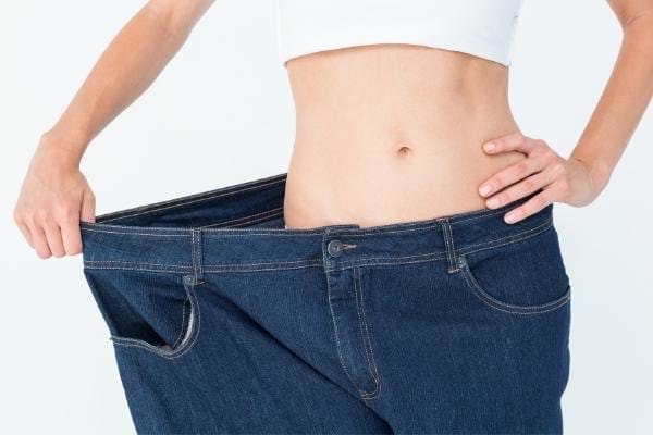 Une femme qui tire son jean pour laisser respirer partie intime