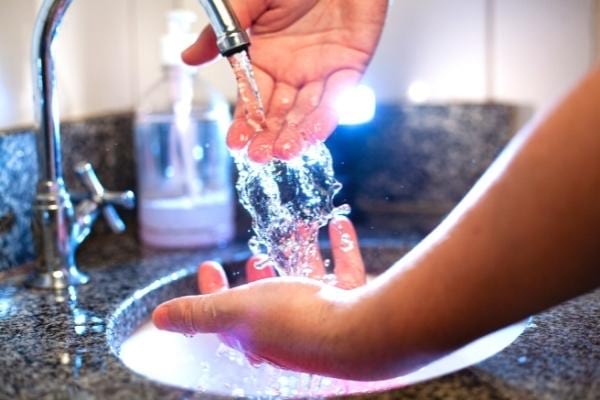 Femme passant de l'eau sur ses mains pour nettoyer sa vulve
