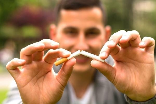 Un homme qui casse une cigarette et arrête de fumer grâce à l'huile d'olive
