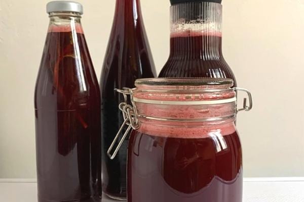 Mehrere Glasflaschen mit Bissap aus Hibiskusblüten