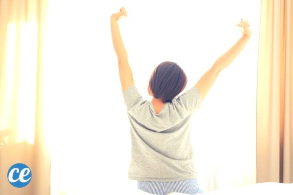 Une femme qui s'étire après une bonne nuit de sommeil parce qu'elle ne mange plsu de sucre.