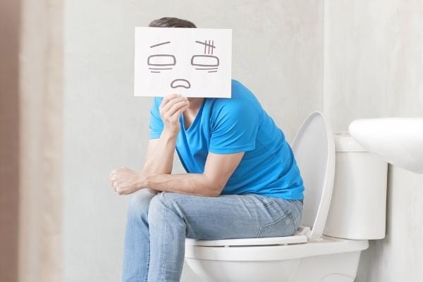 Un homme constipé qui va mieux avec de l'huile d'olive