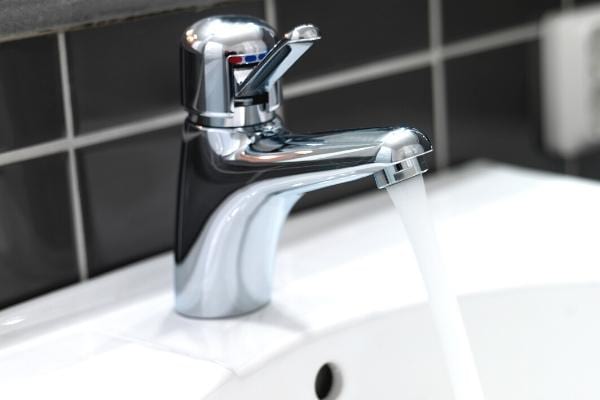 Un robinet laissé sur l'eau chaude qui consomme de l'électricité