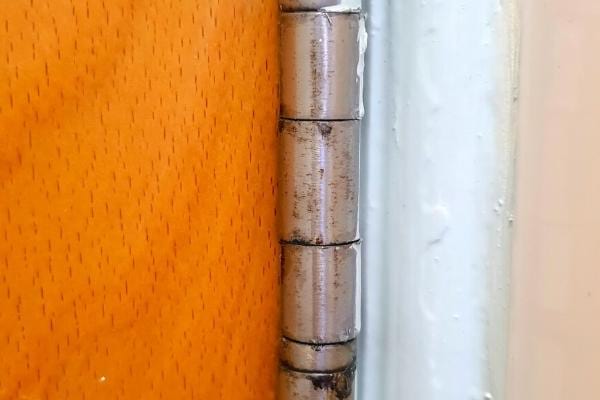 Une charnière de porte qui ne grince plus grâce à de l'huile d'olive