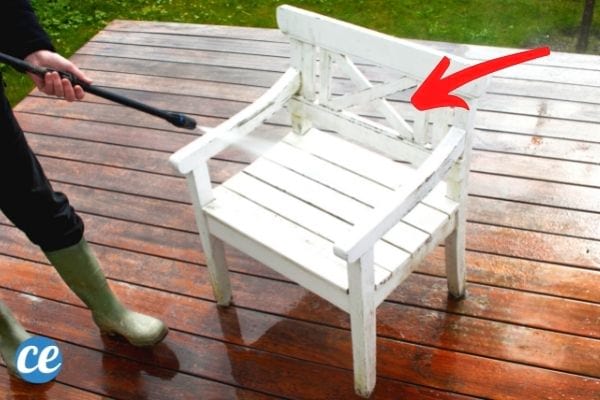 Un Karcher haute pression qui nettoie une chaise de jardin en bois.