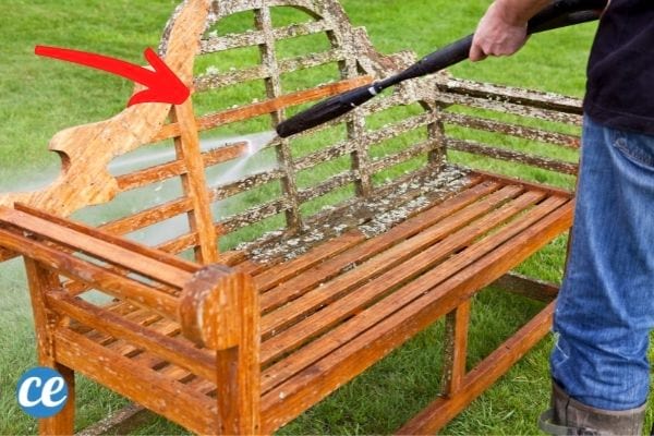 Un Karcher qui nettoie une chaise de jardin sur du gazon.