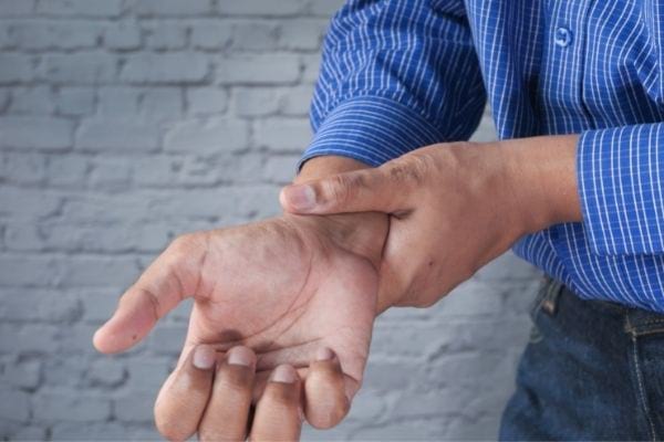 un homme se tient le poignet