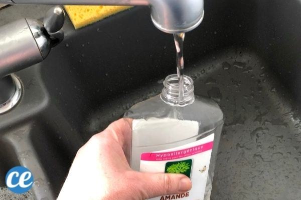 de l'eau versée dans un flacon de produit vaisselle pour le faire durer plus longtemps