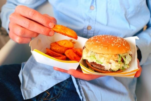 Un homme qui mange des aliments de fast food riche en cholestérol mauvais pour la santé