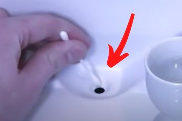 Un coton tige pour nettoyer le drain du réfrigérateur