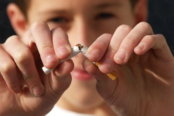 un enfant casse une cigarette