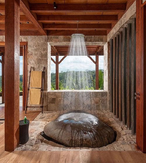 Une douche en extérieur au dessus d'une grosse roche