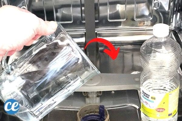 une bouteille de vinaigre blanc et un récipient rempli de vinaigre blanc pour nettoyer le lave-vaiselle