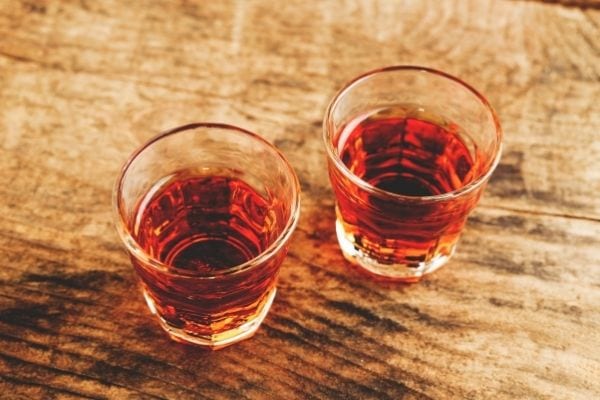 deux petits verres sur une planche en bois rempli d'alcool